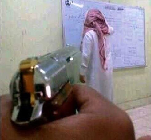 صورة طالب يصوب مسدساً تجاه معلمه تثير جدلاً بالسعودية!؟