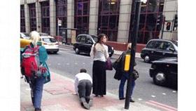 امرأة تسحب رجلاً بسلسلة من عنقه وتتجول به في شوارع لندن جاثياً على ركبتيه