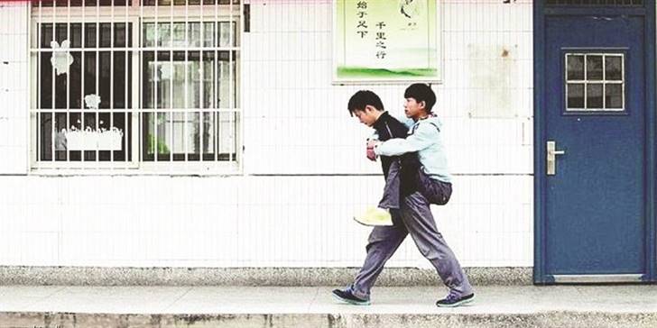 صيني يحمل صديقه المعاق إلى المدرسة… يومياً