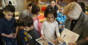 BERLIN, GERMANY - DECEMBER 16: German Education Minister Johanna Wanka (R) and Stiftung lesen foundation head Joerg Maas (L) share games and books with immigrant children during the presentation of a new initiative to help children of refugees learn to read German at a shelter for migrants and refugees on December 16, 2015 in Berlin, Germany. Germany is expected to receive over one million migrants seeking asylum in 2015 and is seeking a rapid integraiton of the newcomers into society and the job market, for which language instruction is a crucial component. (Photo by Sean Gallup/Getty Images)