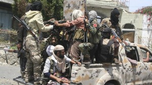Pro-government fighters ride on the back of a truck in Yemen's southwestern city of Taiz