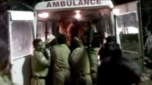 Police rush injured into an ambulance after a fire broke out as people gathered for a fireworks display at a temple in Kollam, southern India