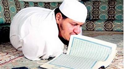 سعودي عاجز عن الحركة يمشي على بطنه يقلب المصحف بأسنانه ويحفظه كاملاً