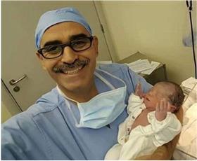 طبيب يلتقط سيلفى مع طفل مولود لحظة الإفطار رافعًا يديه للسماء