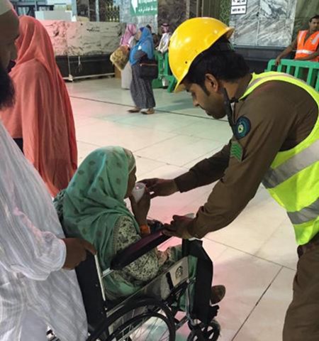 صورة لرجل أمن سعودي يسقي معتمرة مسنة أنهكها التعب تلقى استحسان المغردين