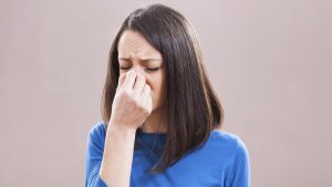 Portrait of young woman who is having pain in her sinus.