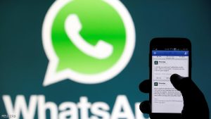 FILE PHOTO: A WhatsApp logo is seen behind a phone that is logged on to Facebook in the central Bosnian town of Zenica