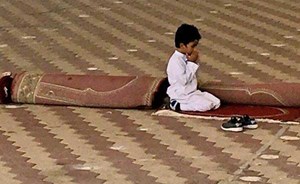 ​صورة مؤثرة لطالب ابتدائي وهو يدعو لوالده المتوفى بخشوع للقائه في الجنة