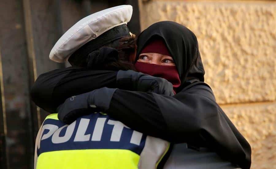صورة شرطية دنماركية تحتضن مسلمة تظاهرت ضد قرار حظر النقاب.. هذه قصتها