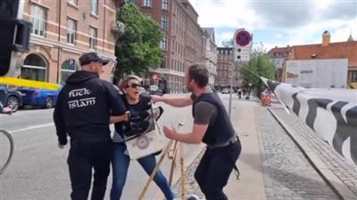سيدة تنقض على حارقي القرآن الكريم في الدنمارك وتنتزعه منهم